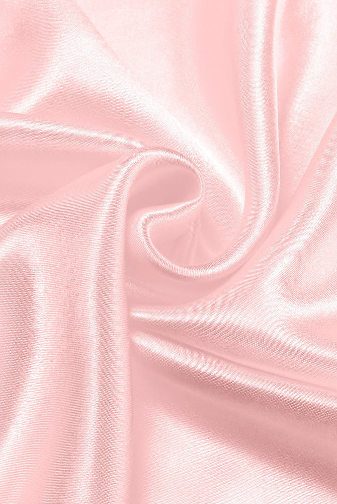 Light pink satin fabric close-up with smooth sheen folds