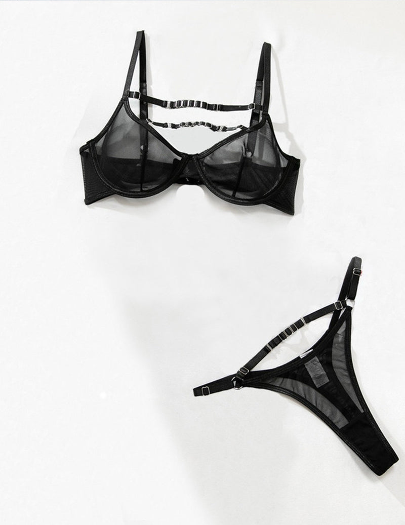 Black sheer mesh bra and panty set with ladder straps and ring detail, flat lay