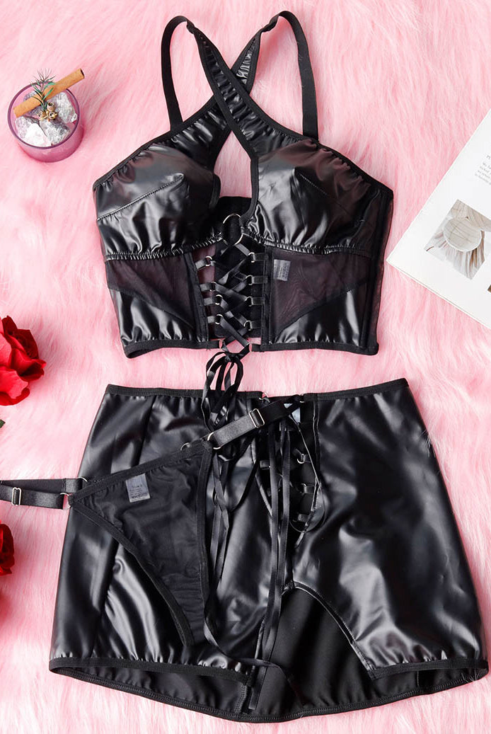 Black PU lingerie set flat lay: halter top with lace-up front and mini skirt
