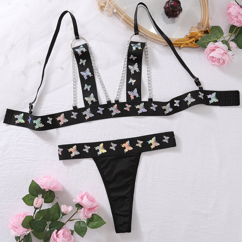 Black butterfly print lingerie set: chain-strap bra top and matching thong, flat lay