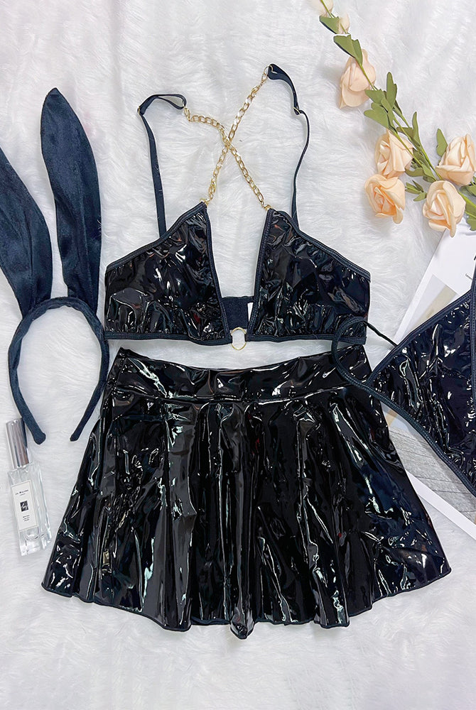 Black PU leather chain bra and mini skirt set with rabbit-ear headband, flat lay