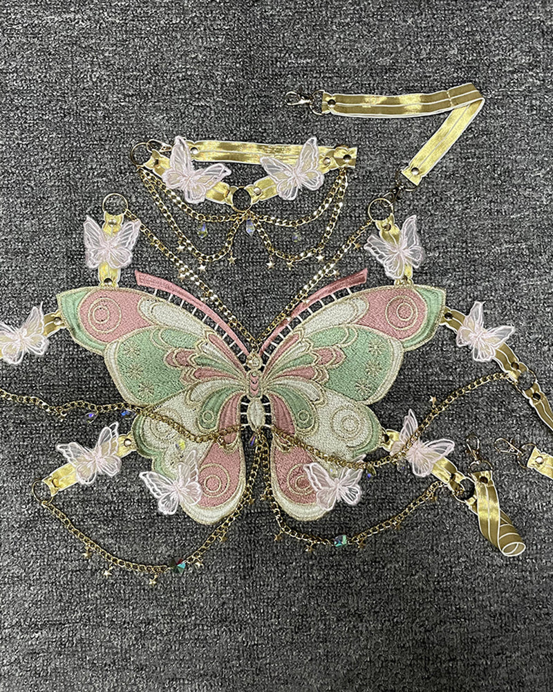 Embroidered butterfly bodice with teal-and-pink wings and gold chain trim