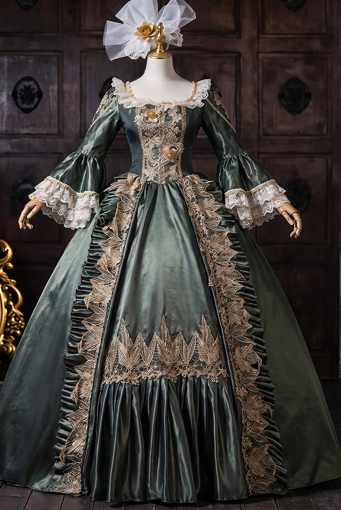 Dark green medieval court gown on mannequin with ornate gold embroidery and lace cuffs