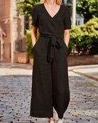 Black romper jumpsuit with V-neck, short sleeves, waist tie belt, wide-leg pants