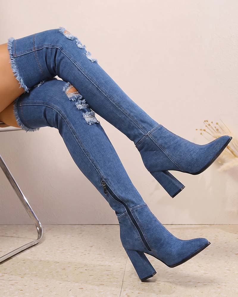 Distressed over-the-knee stiletto boots in blue denim, pointed toe, tall block heel, side zip.