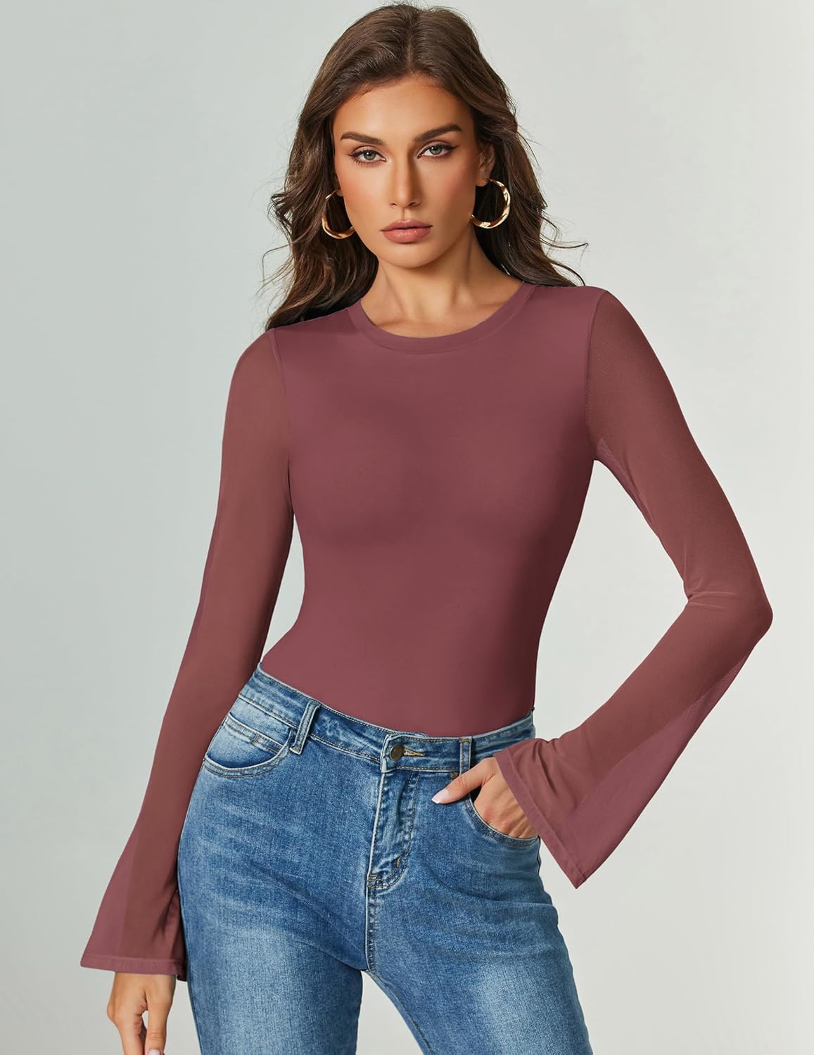 Long-sleeve bodysuit in dark plum with flared cuffs, paired with jeans