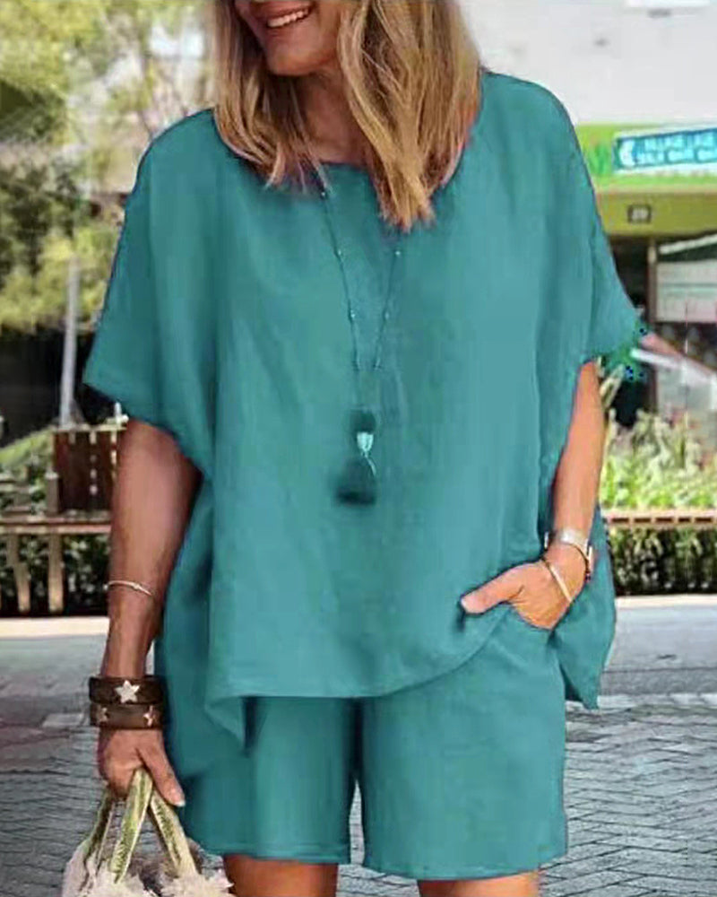 Teal two-piece shorts set with loose short-sleeve blouse-style top and matching shorts