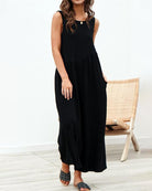 Sleeveless wide-leg jumpsuit in black with tiered waist and ankle-length flowy legs