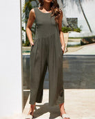 Sleeveless wide-leg jumpsuit in dark olive with tiered waist and relaxed ankle cuffs