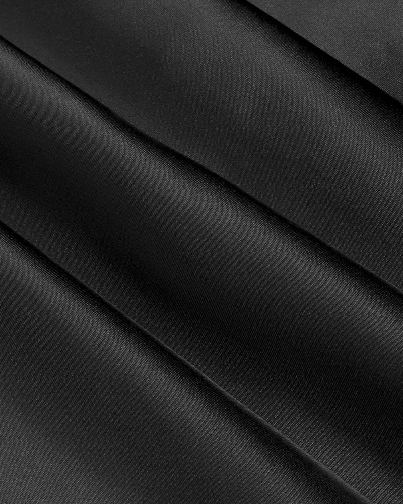 Black satin fabric with smooth sheen and diagonal fold lines