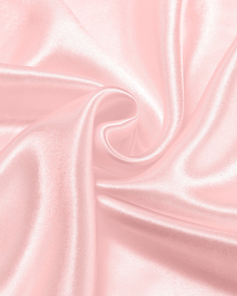 Light pink satin fabric close-up with smooth sheen folds