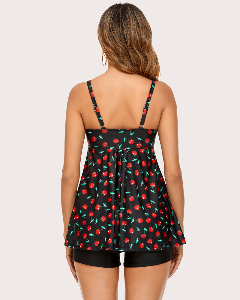 Back view of cherry print tankini top with thin straps and black swim shorts