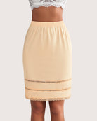 Nude knee-length skirt with elastic waistband and lace trim along the hem