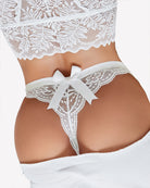 Close-up of white lace T-back thong with bow at front and scalloped trim