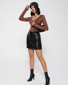 Black double-lined tummy control bodysuit with long sleeves, worn under a mini skirt.