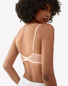 Light pink lace unlined strappy bra side view with adjustable straps and lace cups