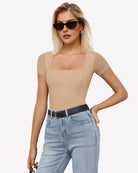 Nude square-neck mesh bodysuit with short sleeves, worn with denim jeans.