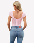Light pink lace bustier crop top back view with scooped open back and cap sleeves