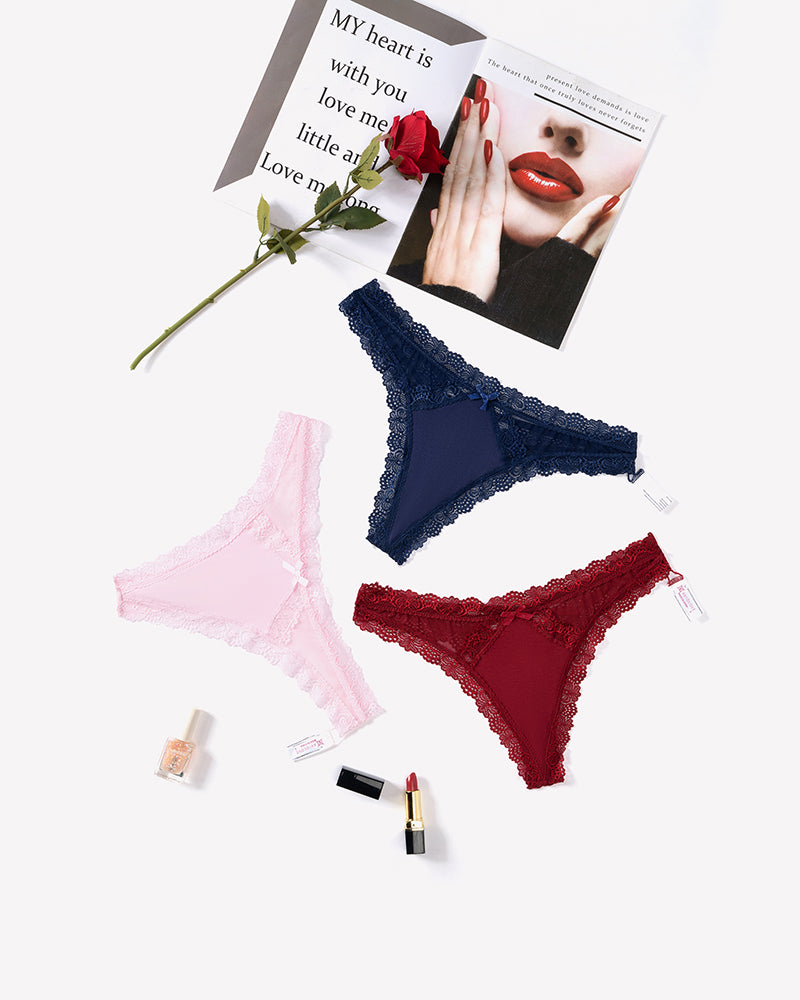 Low-rise lace thong assortment in dark navy, blush pink, and wine red with scalloped trim
