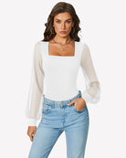 White puff long-sleeve bodysuit with square neckline, worn over blue jeans