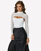 White long-sleeve bodysuit with chest cutout paired with black midi skirt