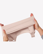 Wireless seamless no-underwire bra band and seamless fabric in light nude, stretched close-up