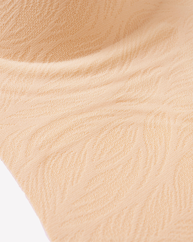 Nude seamless bra fabric close-up with textured knit finish