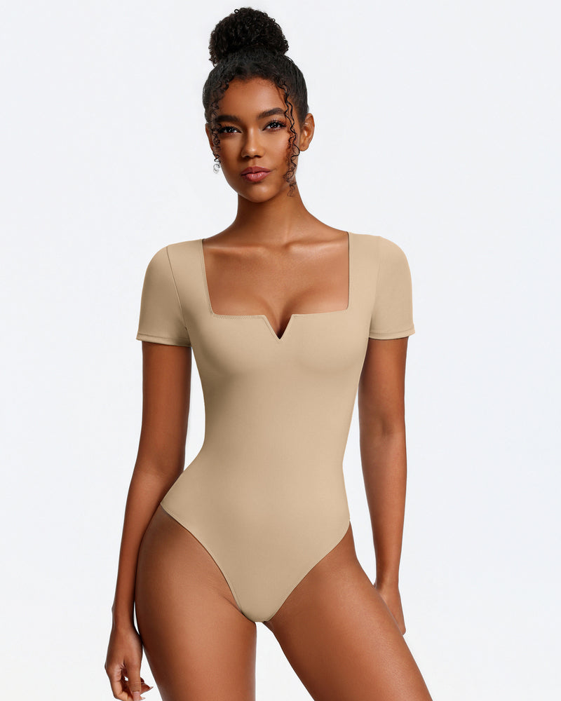 Nude short-sleeve square-neck bodysuit, fitted one-piece with thong bottom.