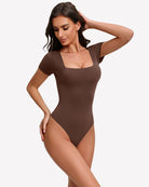 Square-neck short-sleeve bodysuit in dark brown, fitted one-piece with thong-style leg openings.