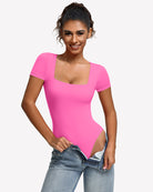 Square-neck short-sleeve bodysuit in hot pink, fitted one-piece with thong-style leg openings.