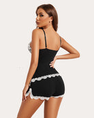 Black lace pajama set with white scalloped trim, spaghetti-strap camisole and shorts
