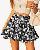Pleated skater skirt in black with white floral print, elastic waist