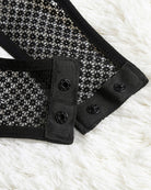 Black mesh snap-crotch bodysuit with buttoned snap placket close-up