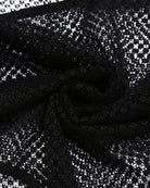 Black lace mesh bodysuit fabric with sheer floral pattern close-up