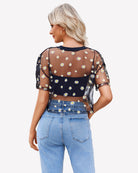 Black sheer mesh crop top with daisy print, back view, short sleeves