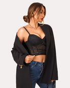 Black lace corset tank top with underwire cups and matching thong, side pose