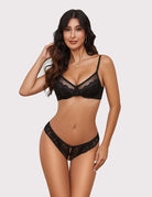 Black lace thong panties with central bow and ribbon ties, front view on model