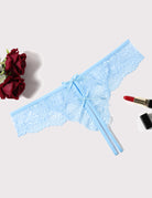 Light blue lace thong panties with bow and ribbon ties, angled flat lay