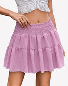 Pink smocked waist A-line short skirt with tiered ruffle layers and gathered hem