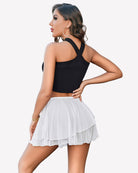White pleated mini skirt with elastic waistband and flared tiered ruffle hem