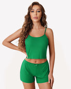 Green ribbed cami pajama set with spaghetti straps and matching drawstring shorts