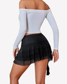Black mini ruffle skirt with layered asymmetric tiers and flared hem