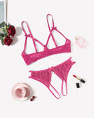 Rose red lace bra and thong set laid flat, with bow accents and scalloped edges