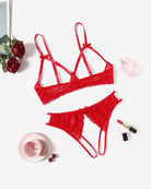Red lace bra and thong set laid flat with bow accents and scalloped trim