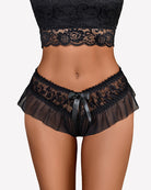 Floral lace briefs in black with tulle ruffle trim and satin bow at center.
