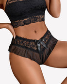 Floral lace briefs in black with tulle ruffle waist and center bow detail, side view.