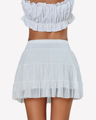 White pleated mini skirt with layered ruffle tiers and elastic waistband