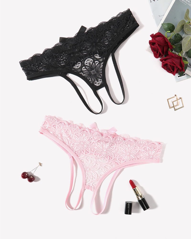 Lace thong briefs in black and light pink with bow accents, laid flat