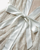 White satin-and-lace nightgown robe detail with bow-tied waist and lace texture