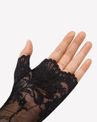 Black lace fingerless wrist glove on open hand with floral lace and sheer mesh